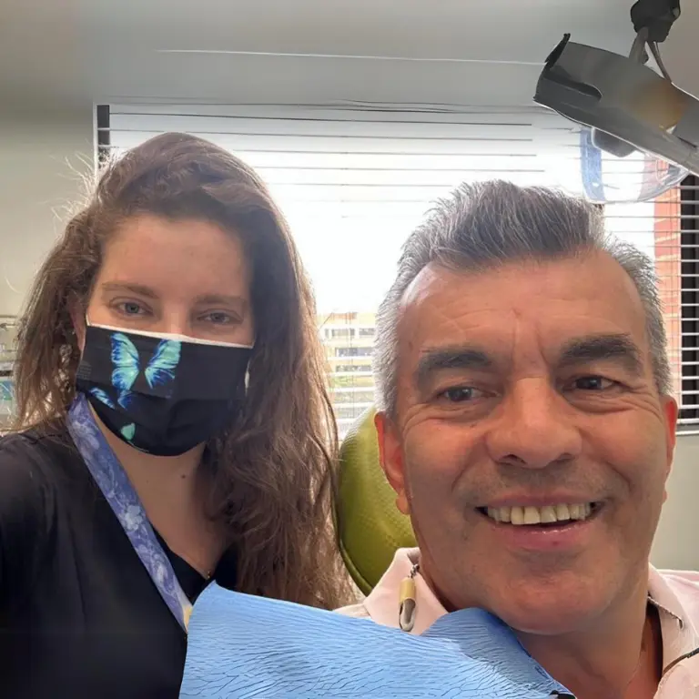 Hombre realizó un implante dental con éxito, foto con la Dra. Verónica Forero en su clínica.